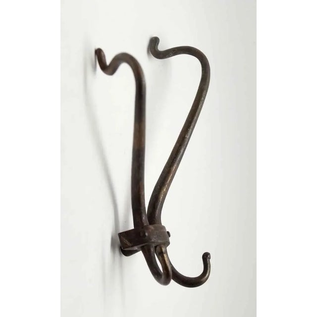 Unusual brass double hook with a dark bronze patina. Good condition with appropriate wear from age. One available. The...