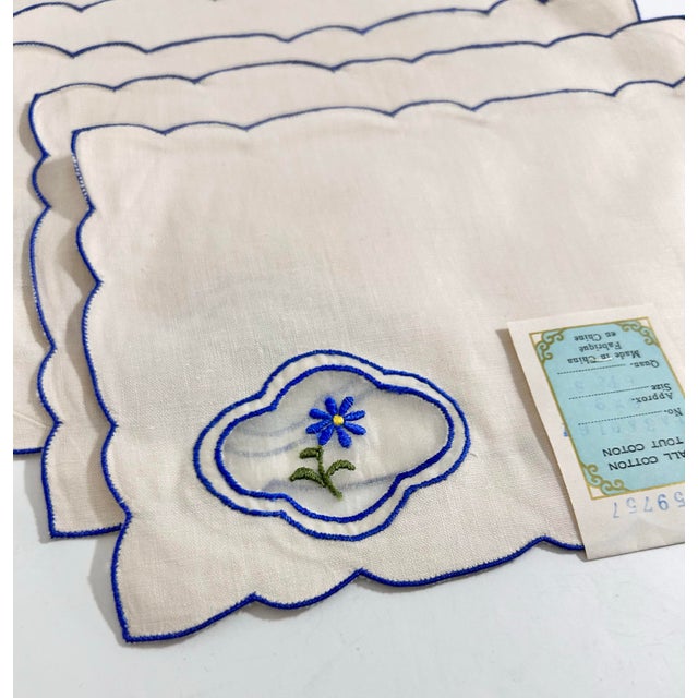 Charming vintage linen cocktail napkins with delicate blue floral embroidery and scalloped edges, crafted in Portugal and...