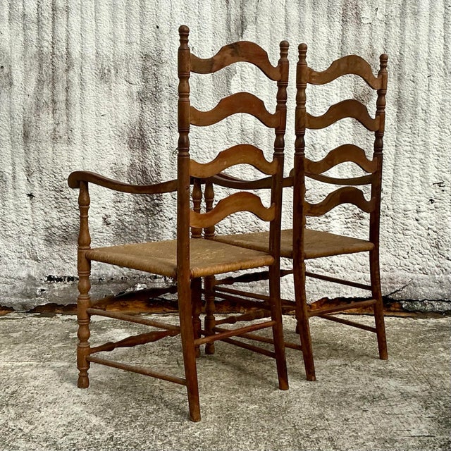 Add a touch of coastal charm to your dining or living area with this pair of Vintage Coastal Ladderback Rush Seat Chairs....