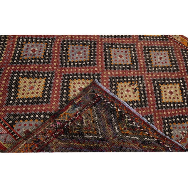Beautiful vintage Sumakh hand-knotted wool rug with a black color field. This Sumakh rug has red, yellow, gray, and white...
