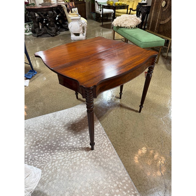 A beautiful early 19th century mahogany Sheraton style flip top game table. Sides are in a serpentine style with outset...