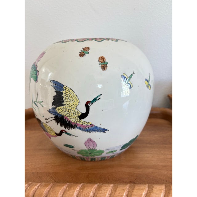 A beautiful vintage Chinese porcelain jardinière featuring a hand-painted crane and lotus motif in soft greens, pinks, and...