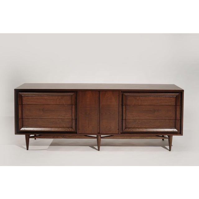 A Mid-Century Modern walnut dresser expertly restored by Stamford Modern. Features six large drawers and bookmatched...