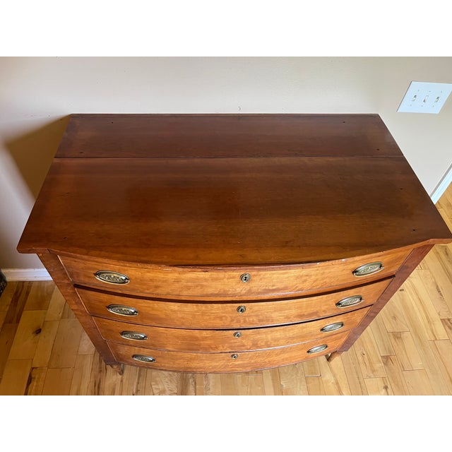 A beautifully preserved example of American Federal-period craftsmanship, this four-drawer bow front chest of drawers...