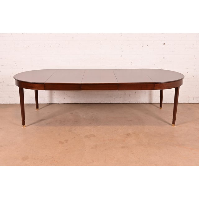 An exceptional antique French Regency Louis XVI style extension dining table In the manner of Baker Furniture USA, Early...
