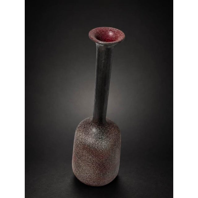 A striking vintage studio pottery vase featuring a richly textured speckled glaze in deep charcoal, burgundy, and muted...