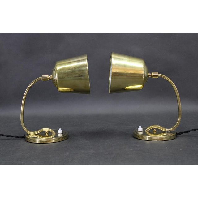 An elegant pair of adjustable brass lamps produced in czechoslovakia during the 1930s, reflecting refined art deco and...
