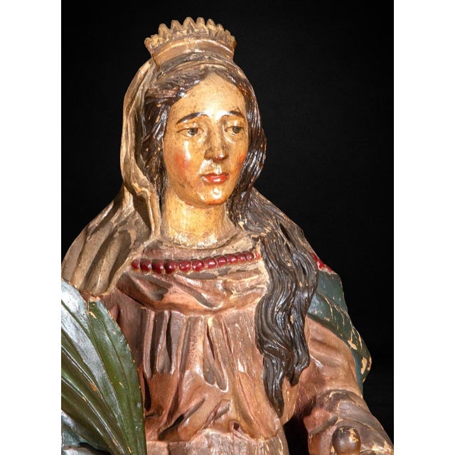 A finely carved and polychromed wooden figure depicting Saint Catherine of Alexandria, Spain, circa 1750–1800. The saint...