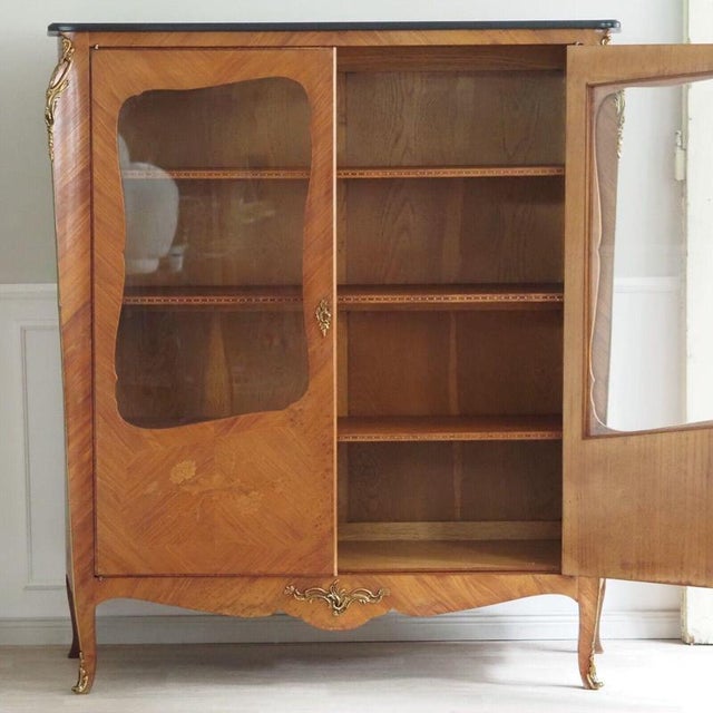 This vintage louis xv reproduction display cabinet is a real eye-catcher! it's crafted from exquisite burl wood veneer and...