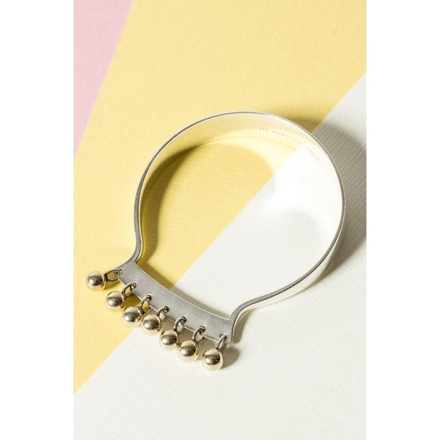 Striking silver bracelet by Bent Gabrielsen Pedersen, with a fringe of kinetic gilded balls. Elegant and playful design....