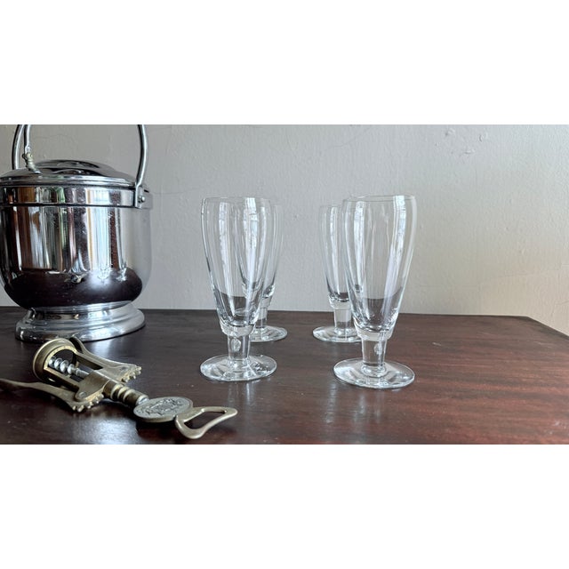 Set of four clear glass pilsner glasses, likely from the Mikasa Brewmaster collection. Each has a footed base and is made...