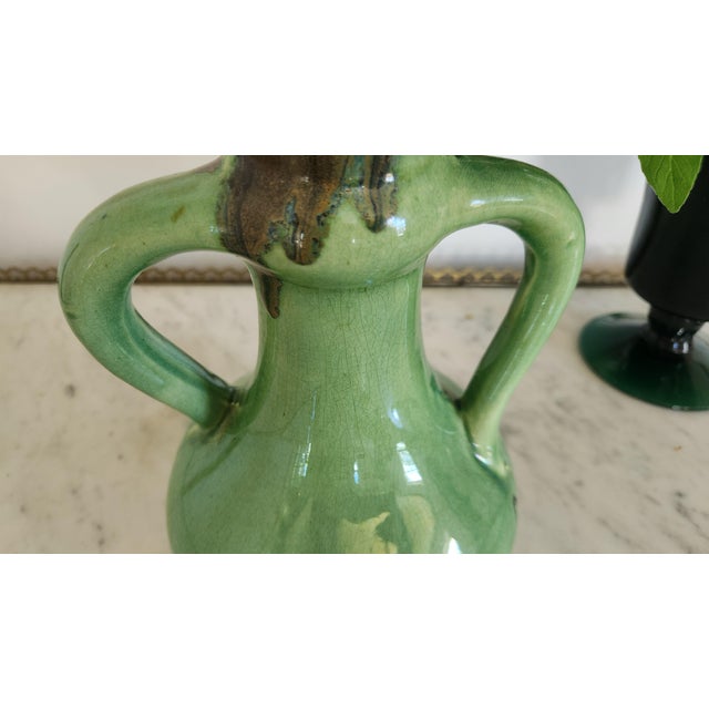 A vintage German ceramic vase marked “Germany 850” on the underside. The piece has a sculptural double-handle amphora form...