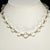 Classic clear faceted glass beads are accented by gold plated spacers in this unmarked necklace. We believe this vintage...