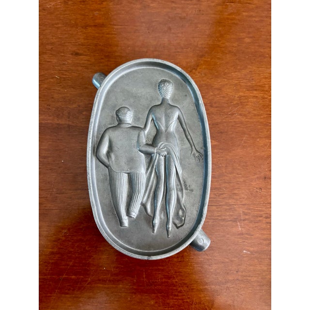 This charming Art Deco–era ashtray, commonly referred to as a “Heads or Tails” or speakeasy ashtray, features a sculptural...
