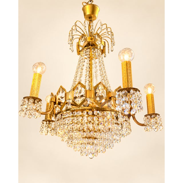 Very beautiful and richly executed vintage chandelier from the 1960s/70s, crafted in brass and fully fitted with cut prism...