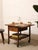 A wonderfully practical vintage rolling table with warm oak tones and a compact, utilitarian silhouette. The top is framed...