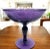 This late 19th to early 20th century amethyst glass compote features an etched floral motif, resting on a tall stemmed...