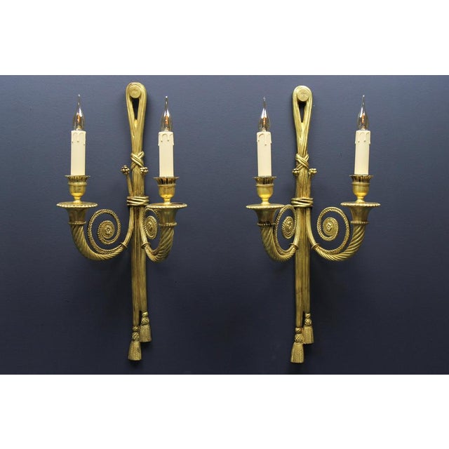 - Pair of French Louis XVI style two-arm ribbon, knot, and tassel sconces, ca. 1910. - An elegant and large set of two...