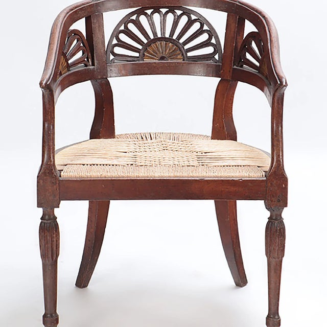 A Pair of Italian walnut open arm chairs with cord seats and cut out design. Circa 1800.