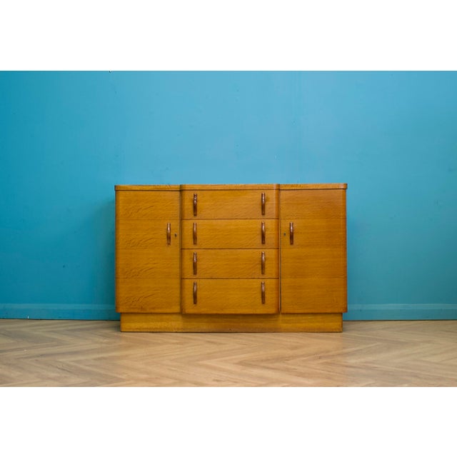 An Art Deco cocktail cabinet dating from around 1940, featuring elegant Streamline Moderne styling with waterfall corners,...