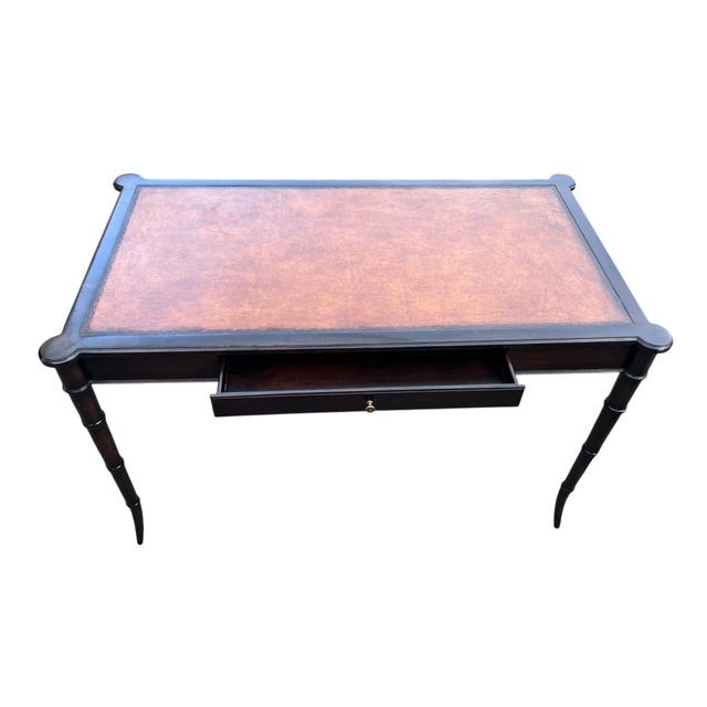 Vintage Regency-Style Black Writing Desk With Brown Inset Top Elegant vintage Regency-style writing desk featuring a rich...