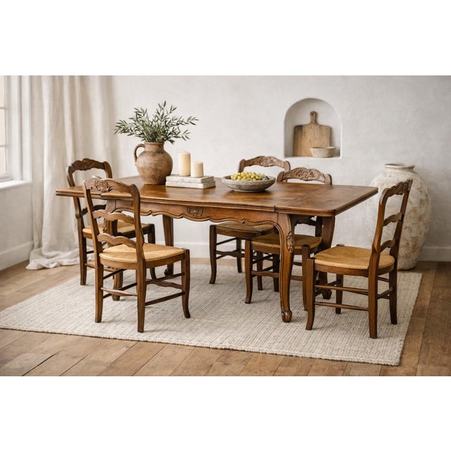 A beautiful antique French Provincial dining table featuring graceful Louis XV–style cabriole legs, a hand-carved...