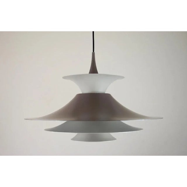 This graduated brown Radius pendant was designed by Erik Baslev for Fog and Mørup. This piece has an attribution mark, I...