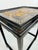 A striking vintage Chinoiserie side table featuring a rich black lacquer-style finish and an ornate raised decorative top....