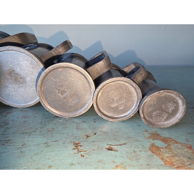 Six graduated pewter measuring pitchers with various stamped information on them. These are from Holland and from the...
