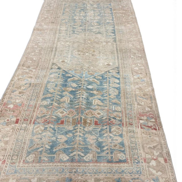 An elegant antique Persian Malayer rug featuring a distinctive geometric medallion and stylized motifs characteristic of...