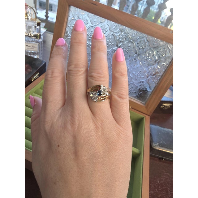 Vintage Blue Sapphire and Diamond Bowtie Cocktail Ring in 14K Gold Circa 1970 This vintage cocktail ring features a...