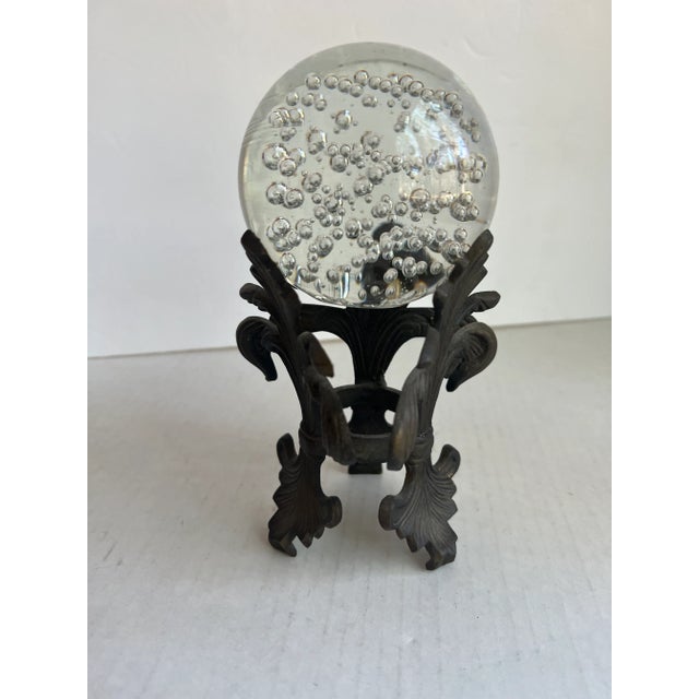 Vintage Art Glass Orb Paperweight with a metal Fleur de Lis Stand. A beautiful piece to add to your home. The glass orb...