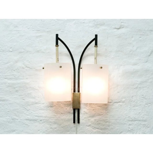 This 1950s Italian wall lamp has a acrylic glass shade and brass detailing. European Plug (up to 250V).The wiring of this...