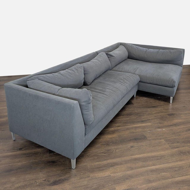 This Crate & Barrel sectional sofa features a sleek, modern design in a versatile gray color. It offers generous seating...
