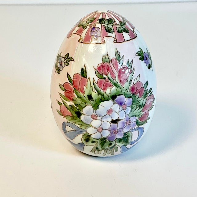 This is a lovely hand-painted ceramic Egg. We love the light pink cabana stripes on the ground. The design is a floral...