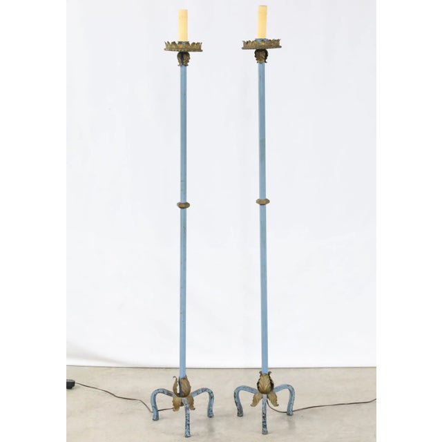 A striking pair of French polychrome torchiere floor lamps featuring slender columns in a soft blue painted finish with...