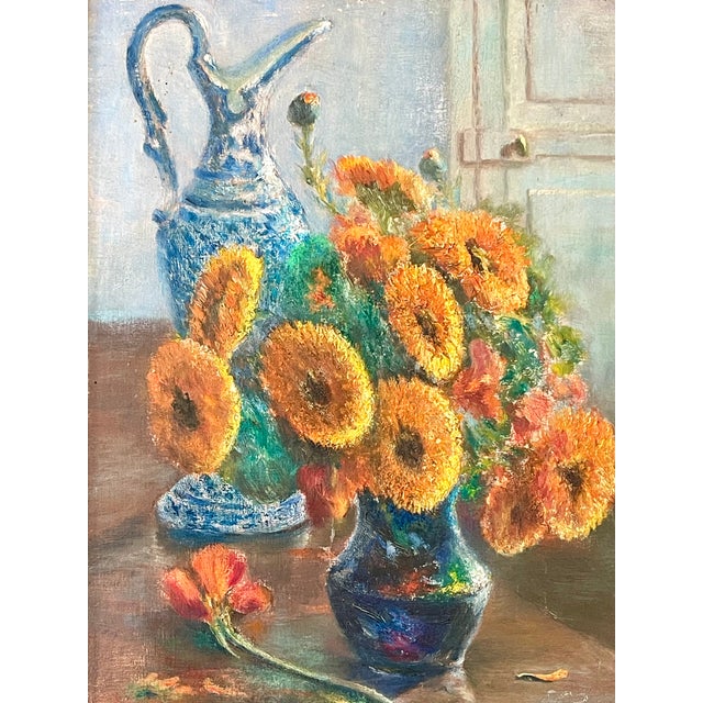 A luminous French mid-century still life of orange sunflowers and a delft vase set in a powder blue room. This oil on...
