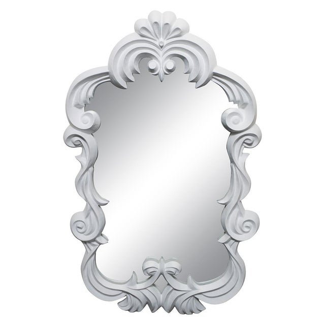 Carved wood mirror with scrolled "ribbon" surround featuring a plaster-like finish.