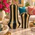 Striking pair of sculptural ceramic vases featuring deeply fluted silhouettes and alternating glossy black and warm tan...