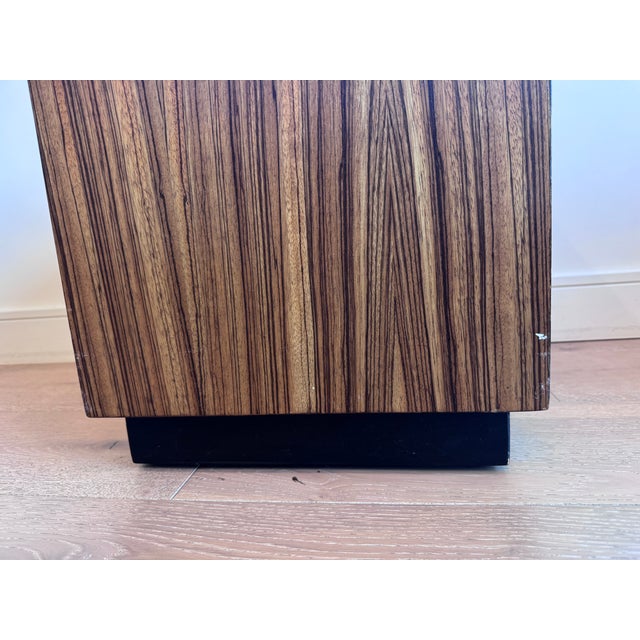 This striking pair of modern cube stools features beautifully figured wood bases paired with tailored brown leather...