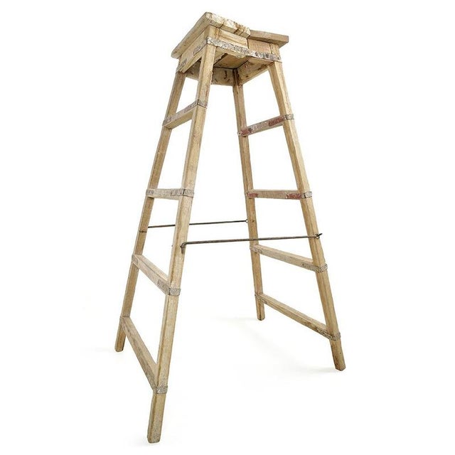 This antique wooden stepladder is captivating with its natural patina and traces of use that bear witness to a...