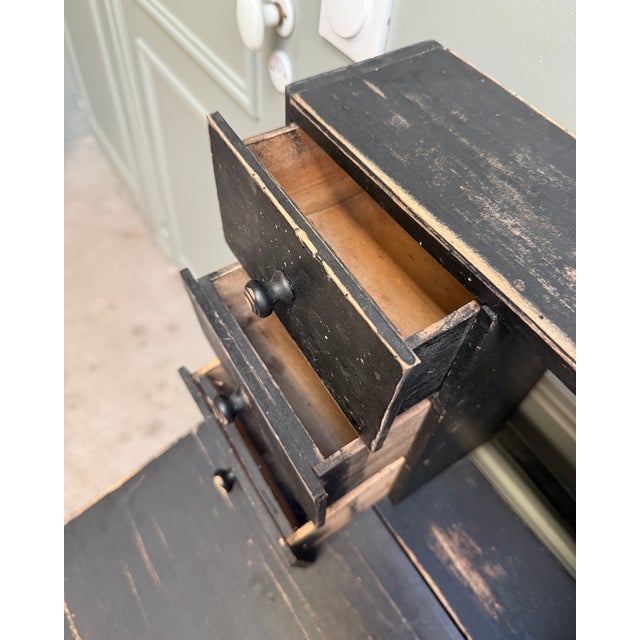 A small secretary desk dating from the early 20th century, remarkable for its narrow dimensions and superb black patina,...