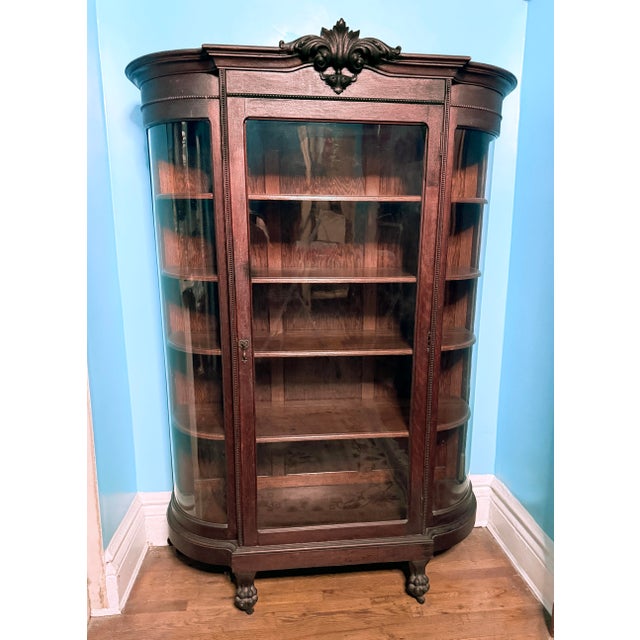 American Victorian/Edwardian china cabinet, circa 1890–1915, crafted from solid quarter-sawn oak with a warm, original...