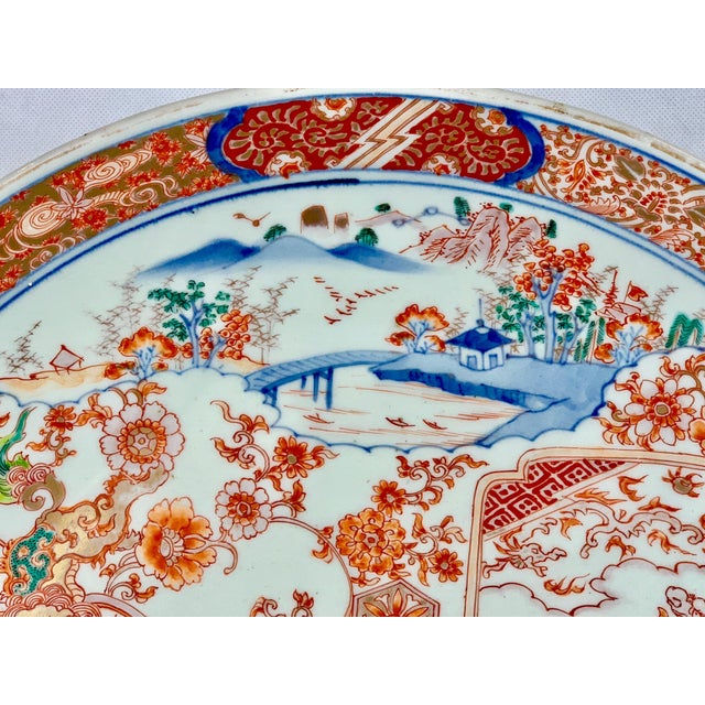 Large finely decorated Meiji period porcelain Imari charger. The decoration consists of shaped panels overlayed on floral...