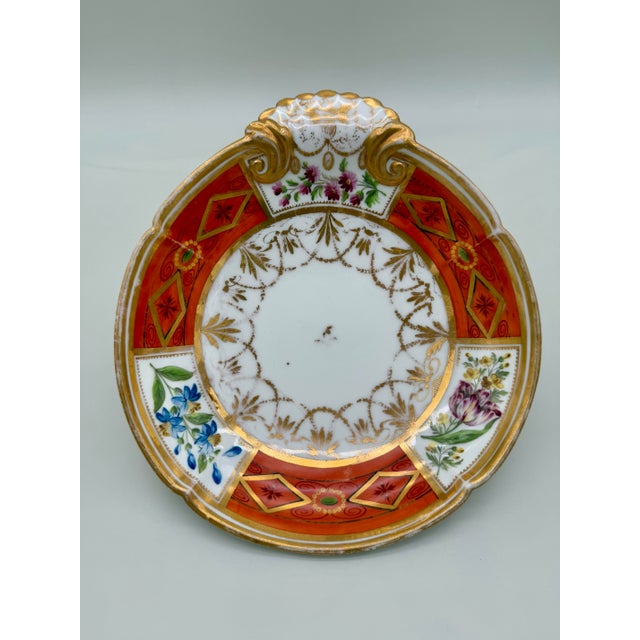 A richly hand-painted and gilded English porcelain plate, attributed to Spode, dating to circa 1800. The plate features a...
