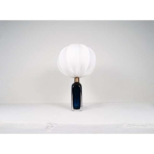 Table lamp in crystal, model rd1406 by carl fagerlund for orrefors, sweden. The lamp have a stunning blue color with brass...