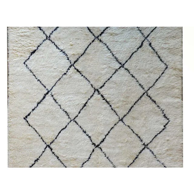 A beautiful vintage Moroccan wool rug with natural undyed white wool with black wool stripes criss-crossing the field.