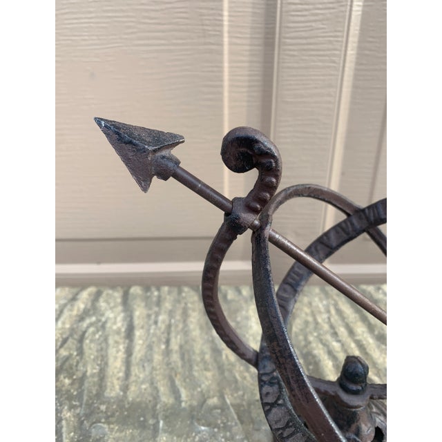 A beautifully crafted iron armillary half-sphere sundial, evoking the timeless elegance of classical European gardens....