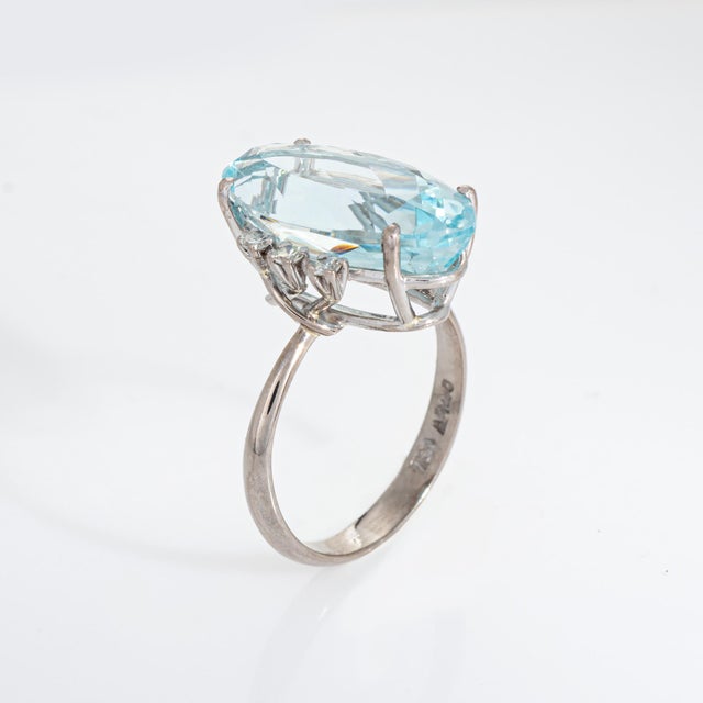 Stylish aquamarine & diamond cocktail ring crafted in 18k white gold. Faceted oval cut aquamarine measures 17.5mm x 9mm...