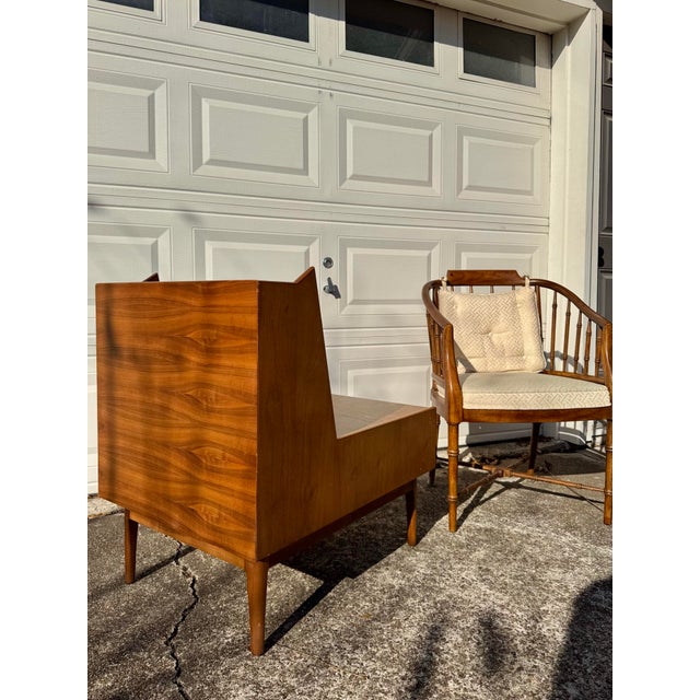 A stunning walnut night stand by Kipp Stewart for the Drexel Declaration line, circa 1960s. The top shelf floats above two...